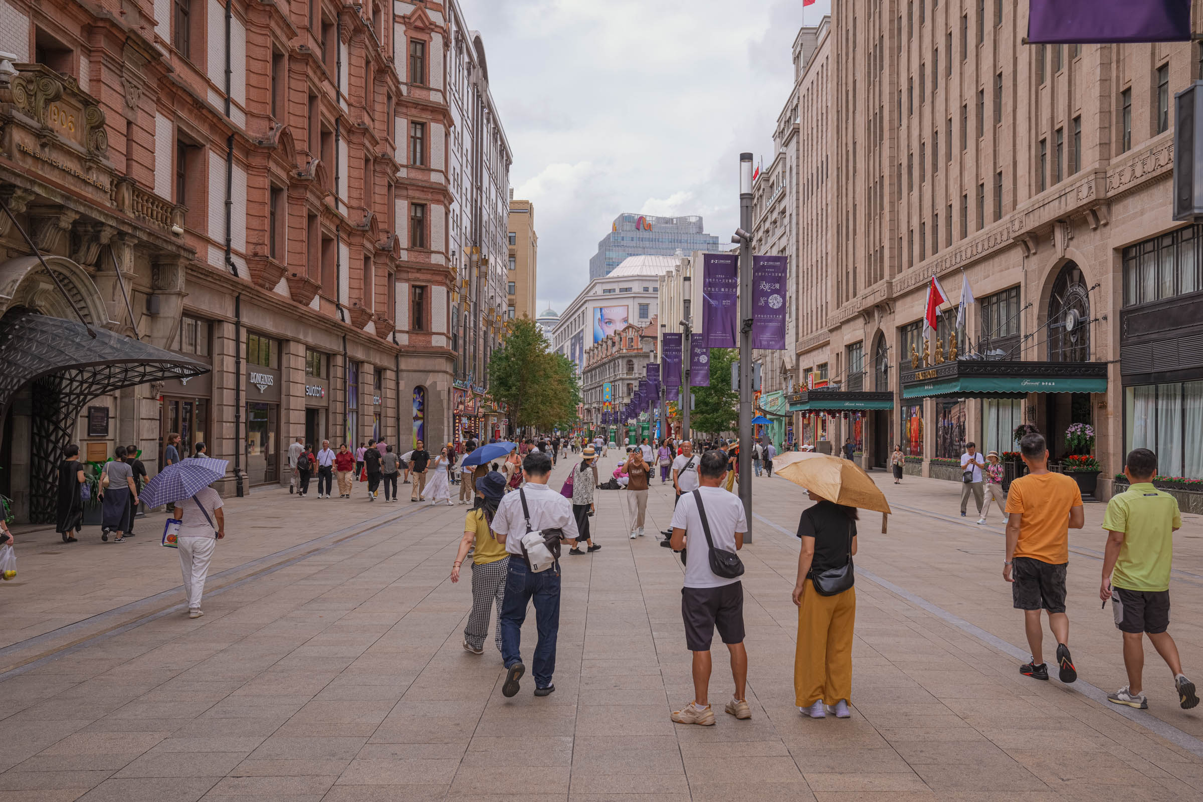 Bustling pedestrian street in Shanghai’s Old City filled with tourists, local shops, and traditional Chinese buildings adorned with curved roofs and red lanterns, creating a lively historic market atmosphere in the metropolis.