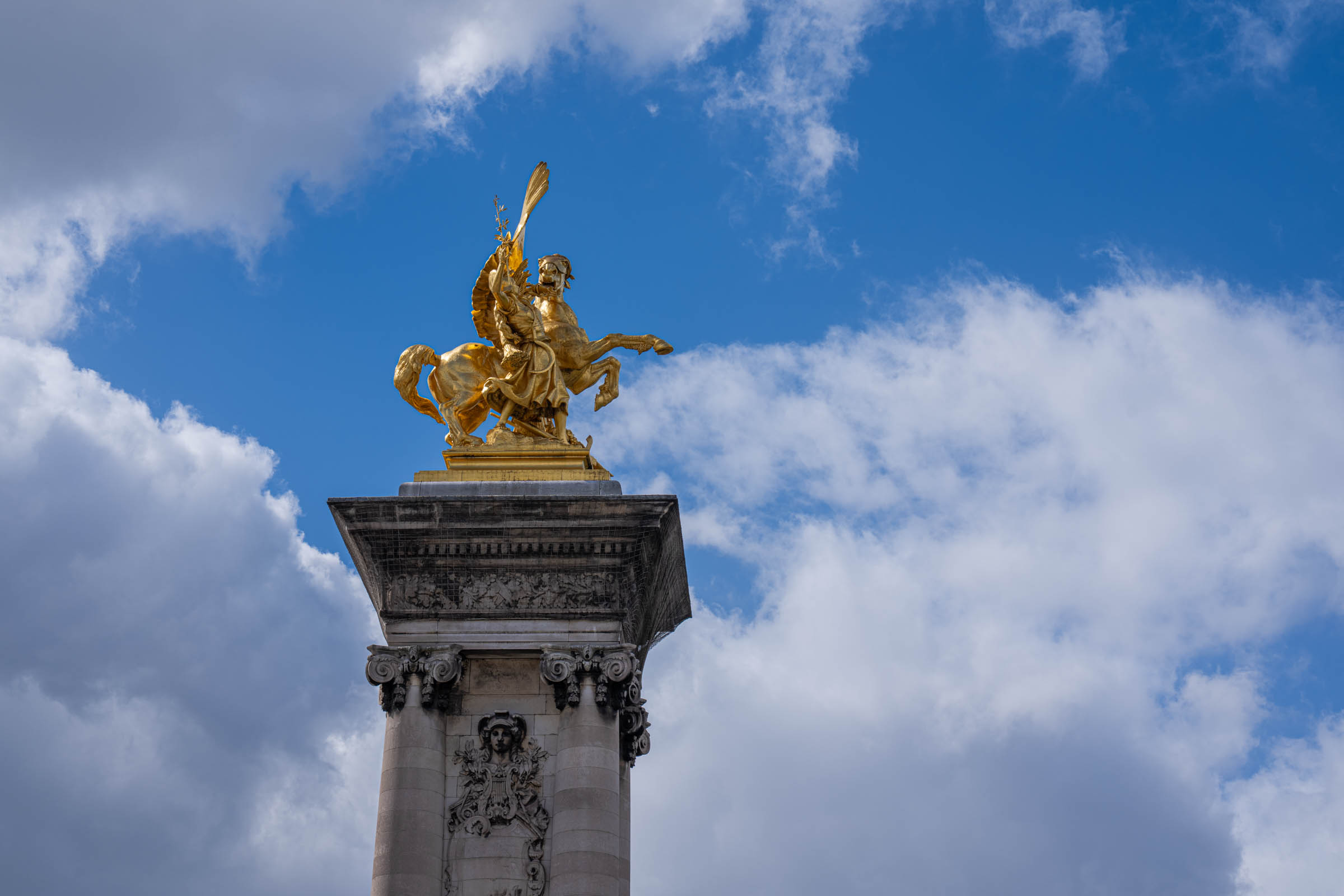 Gilded winged statue crowning one of the columns of the Pont Alexandre III in Paris