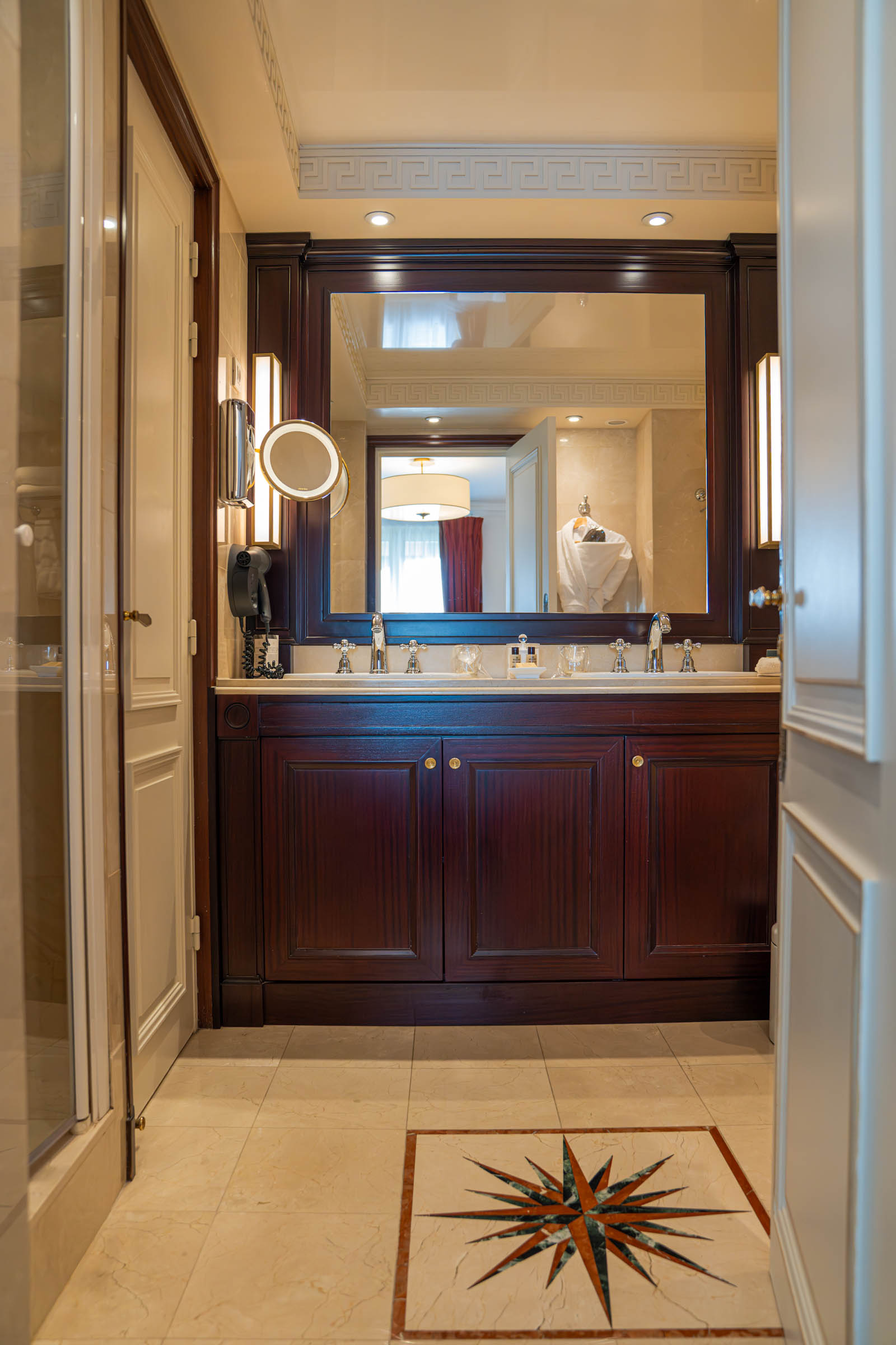 Marble bathroom at Hôtel Napoléon Paris featuring a compass-motif mosaic floor in the five-star suite
