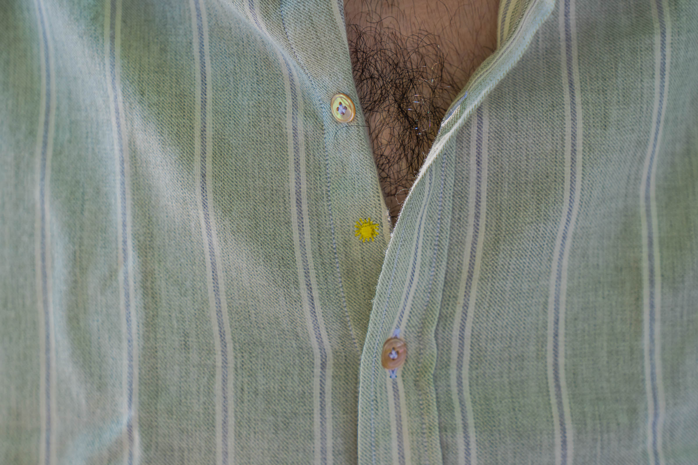 Torso detail of the Giannetto Portofino washed cotton-wool shirt in sage green with white stripes and mother-of-pearl buttons, an Italian-made piece styled by Marko Tadić for a quiet luxury summer look in Belgrade.