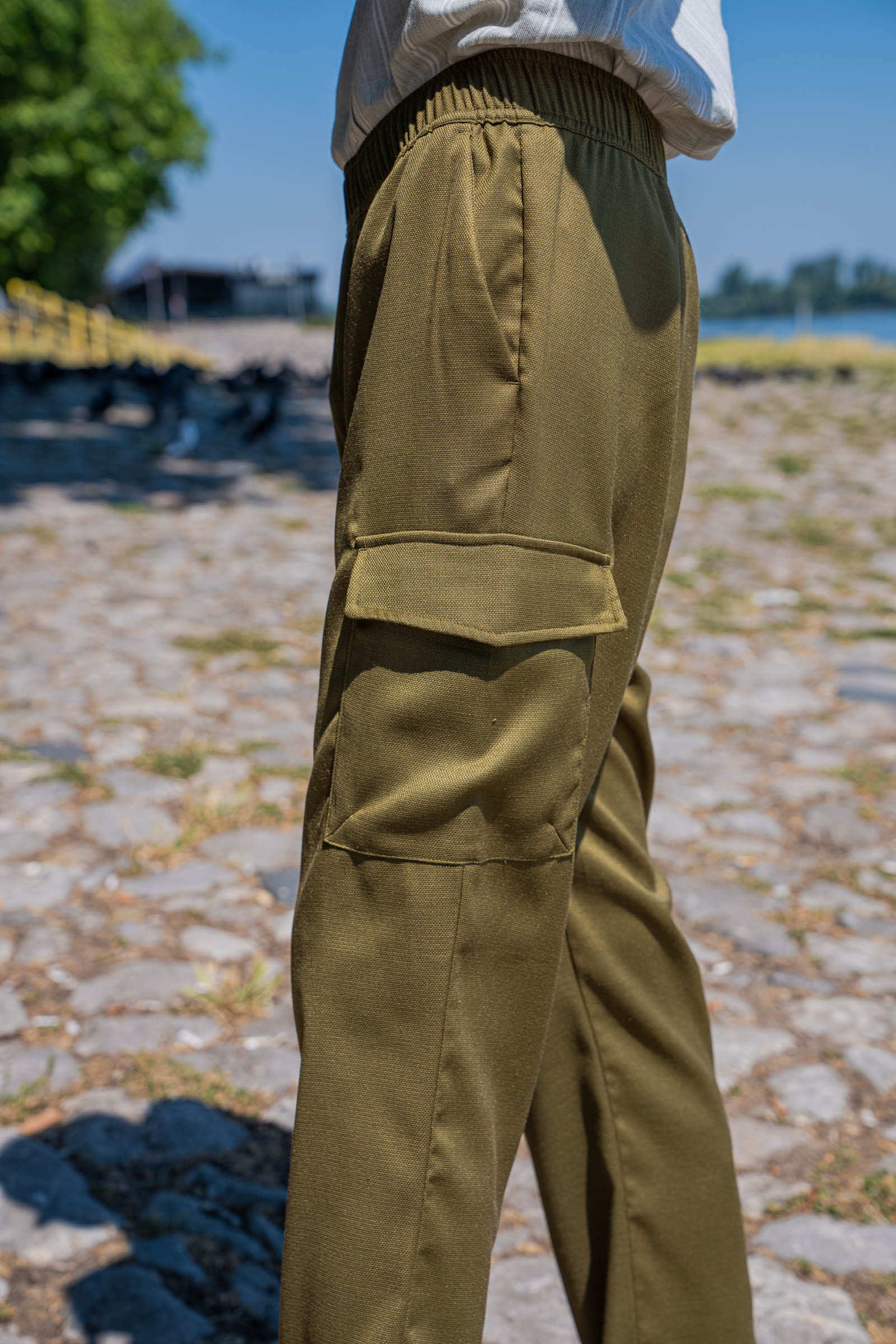 Side profile of Loro Piana cargo trousers in olive green linen-silk blend, showing the elasticated waistband and tailored cargo flap pocket, styled by menswear blogger Marko Tadić of Mr.M by Marko Tadic.