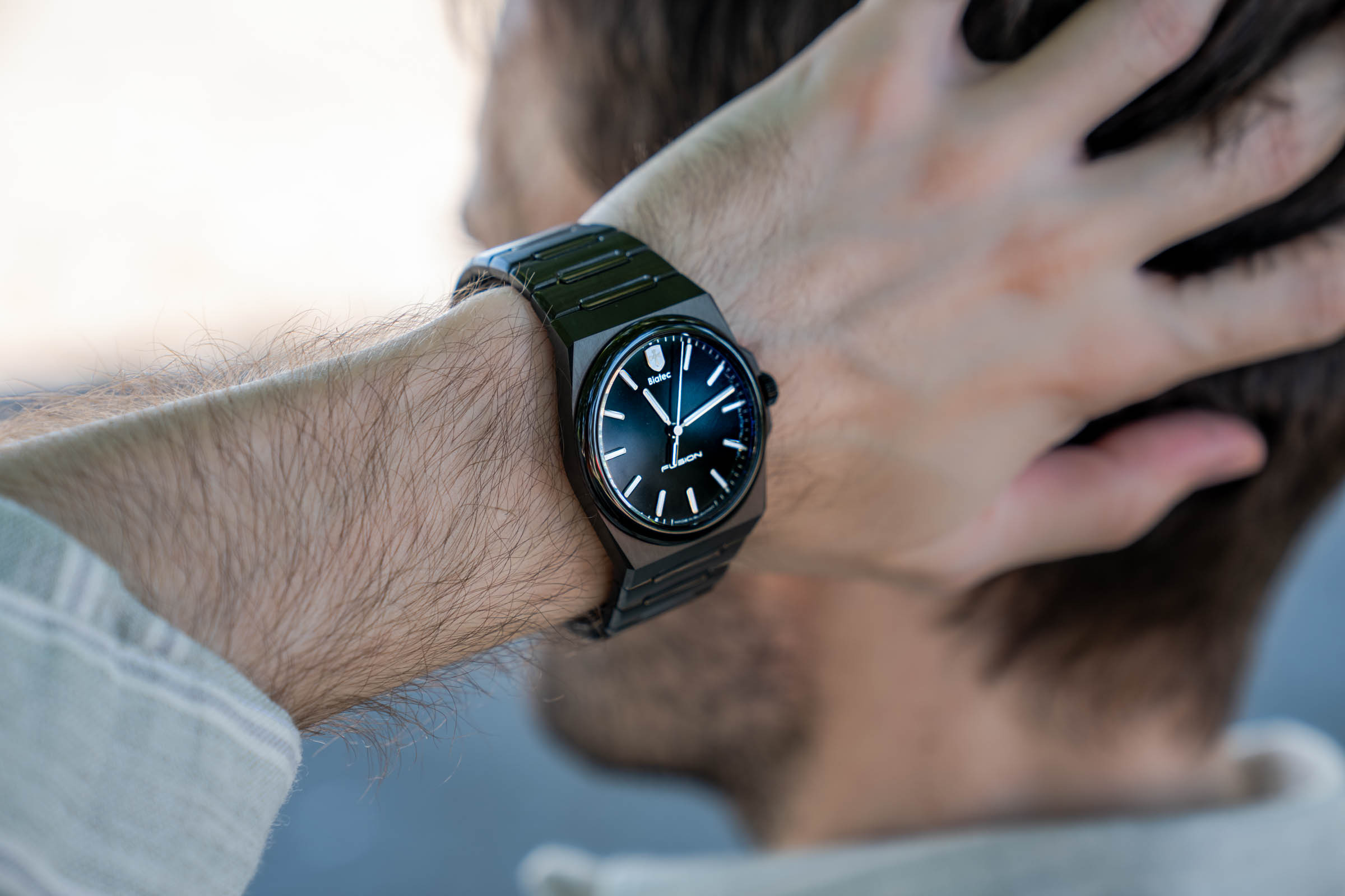 Marko Tadić runs a hand through his hair, revealing the Biatec Fusion 03 black integrated-bracelet watch on his wrist, a Made in Slovakia timepiece completing his quiet luxury summer outfit in Belgrade.