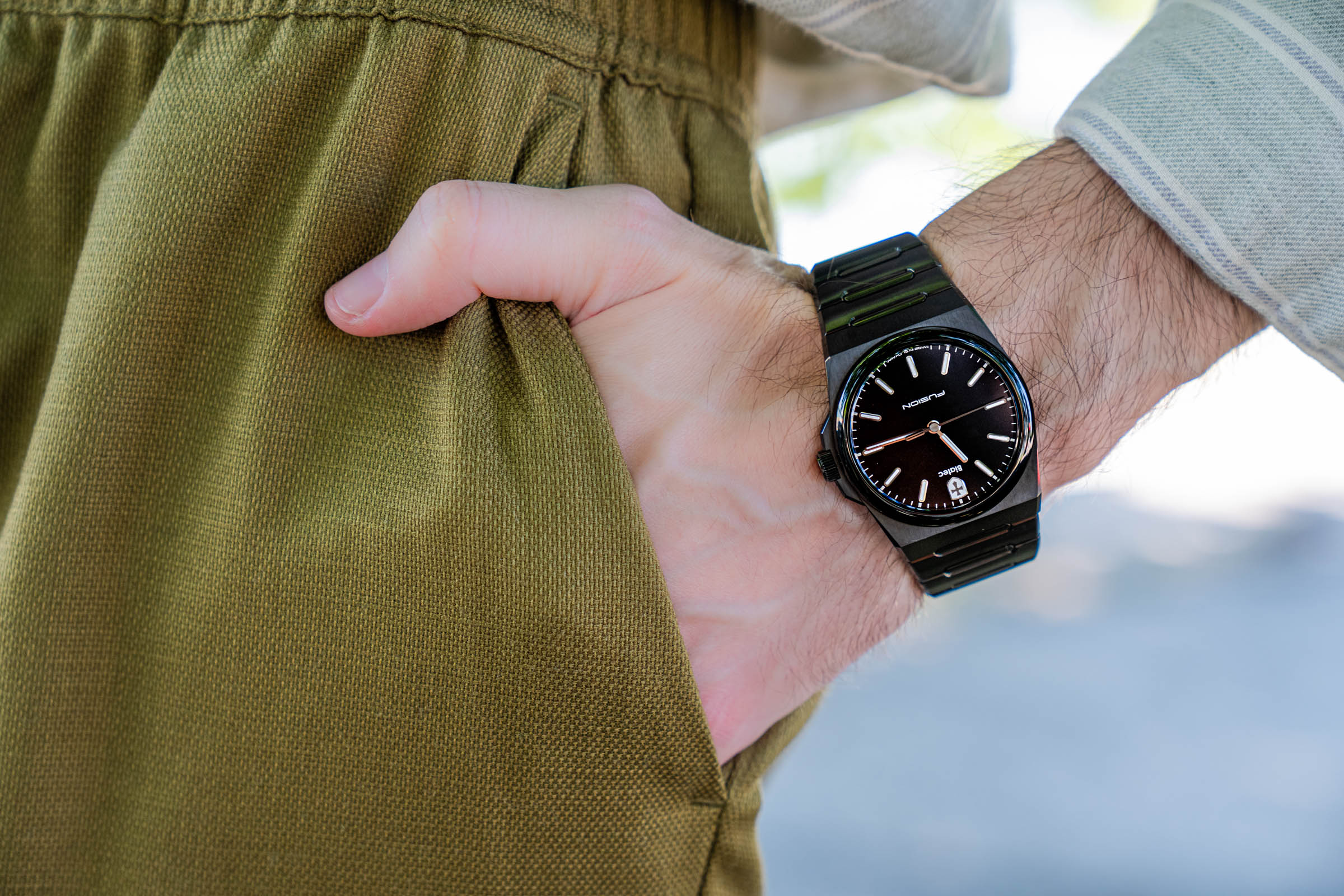 Biatec Fusion 03 wrist shot by Mr.M by Marko Tadic blog, capturing the slim 9 mm profile and sapphire crystal of this all-black Slovak automatic watch against a sage green striped shirt backdrop.