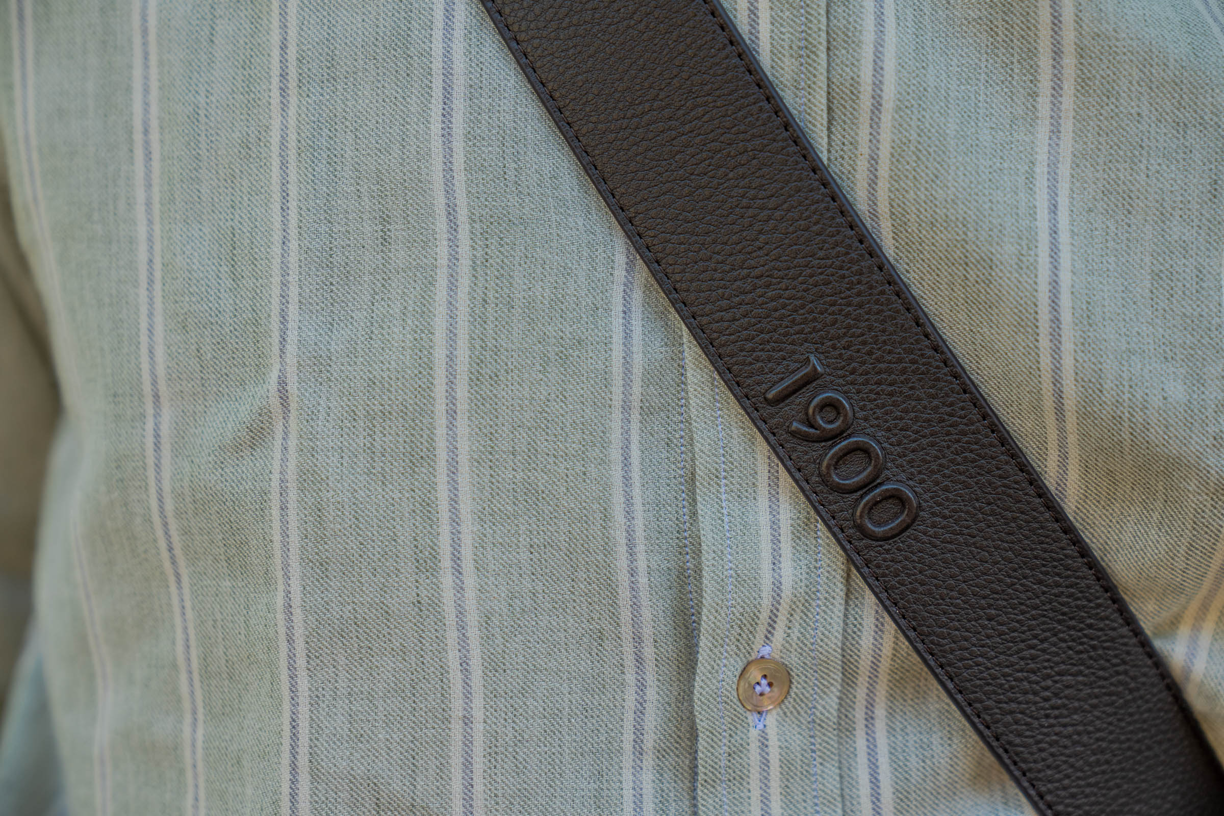 Close-up of the Giannetto Portofino striped shirt showing its spread collar, natural mother-of-pearl buttons and the brand's signature yellow embroidered sun detail beside the placket, worn by blogger Marko Tadić.