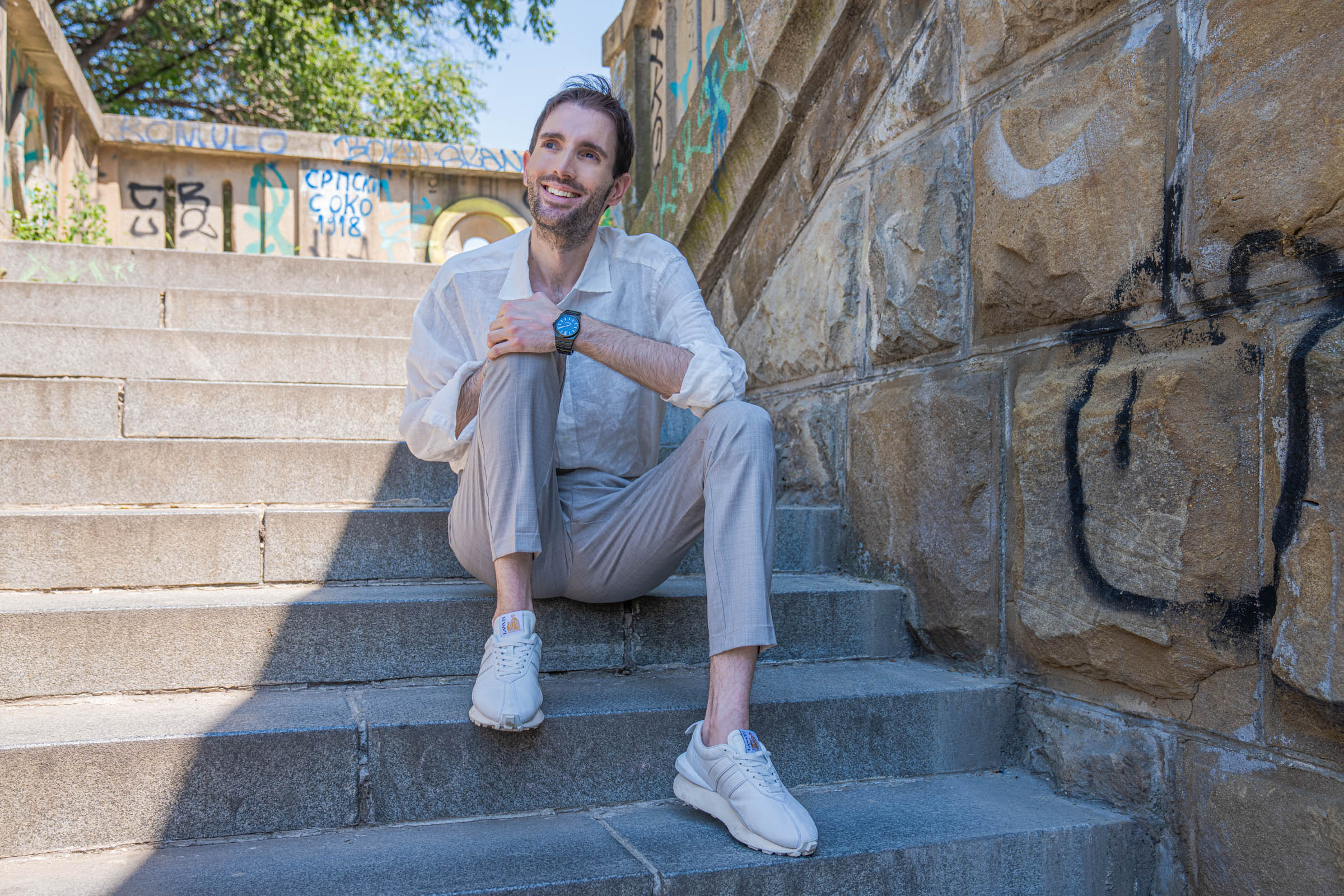 Marko Tadić, founder of the Mr.M blog, sitting on stone steps with his hand under his chin, wearing the black Biatec Fusion 03 watch
