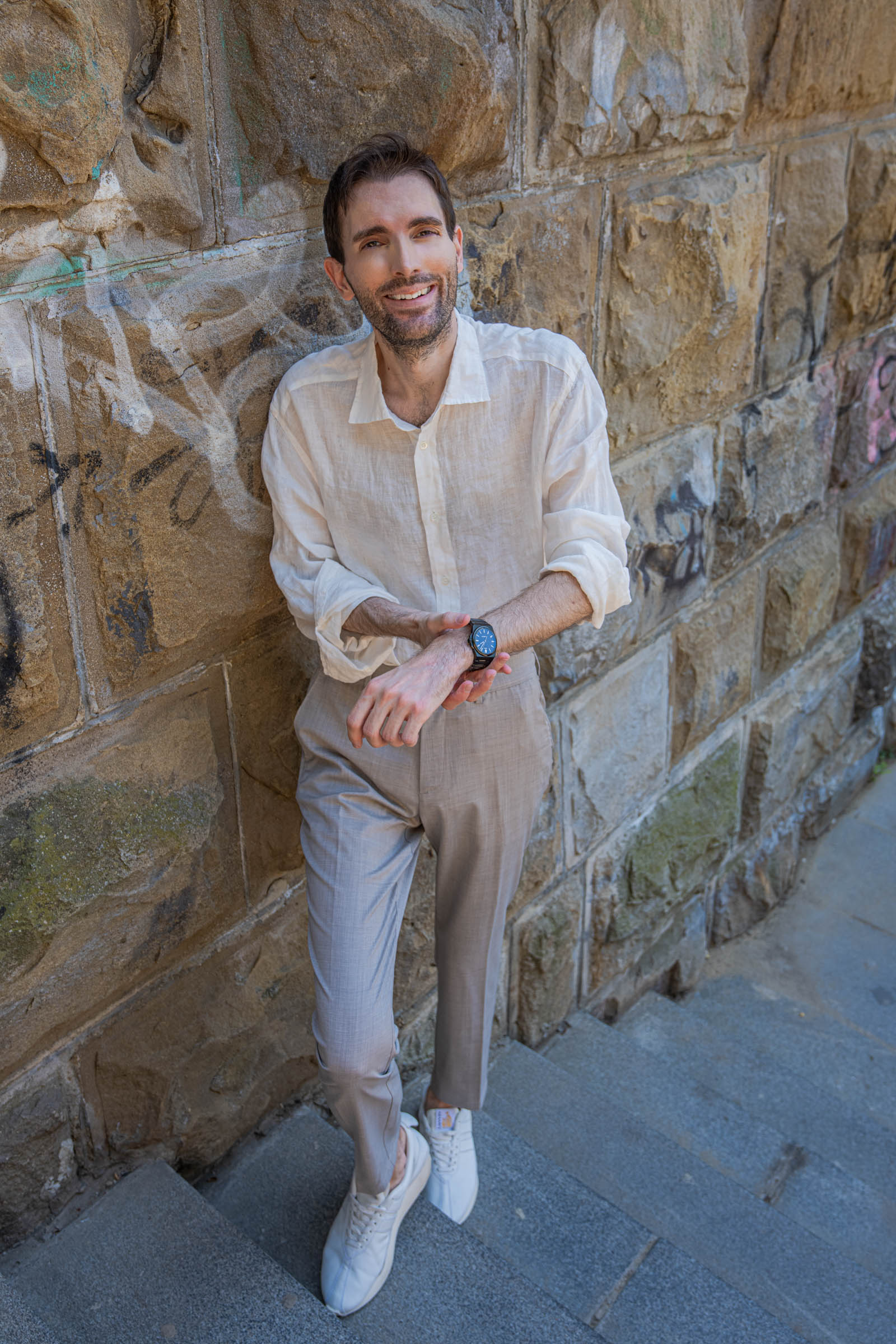 Marko Tadić, founder of the Mr.M blog, leaning against a stone wall and showing the black Biatec Fusion 03 automatic watch on his wrist