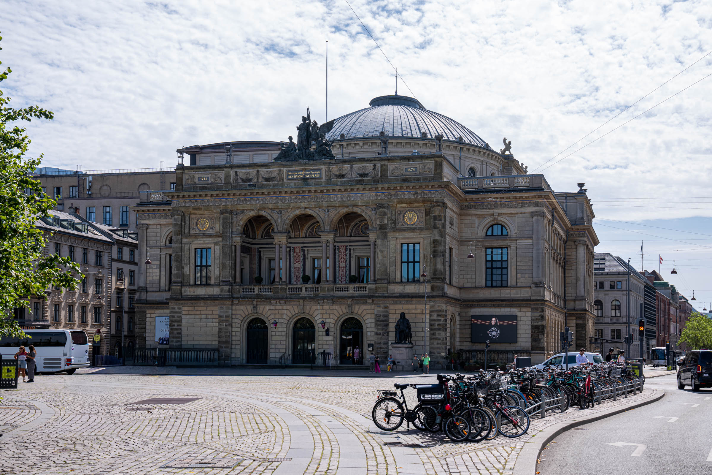 The Royal Danish Theatre on Kongens Nytorv in Copenhagen with rows of parked city bicycles in front