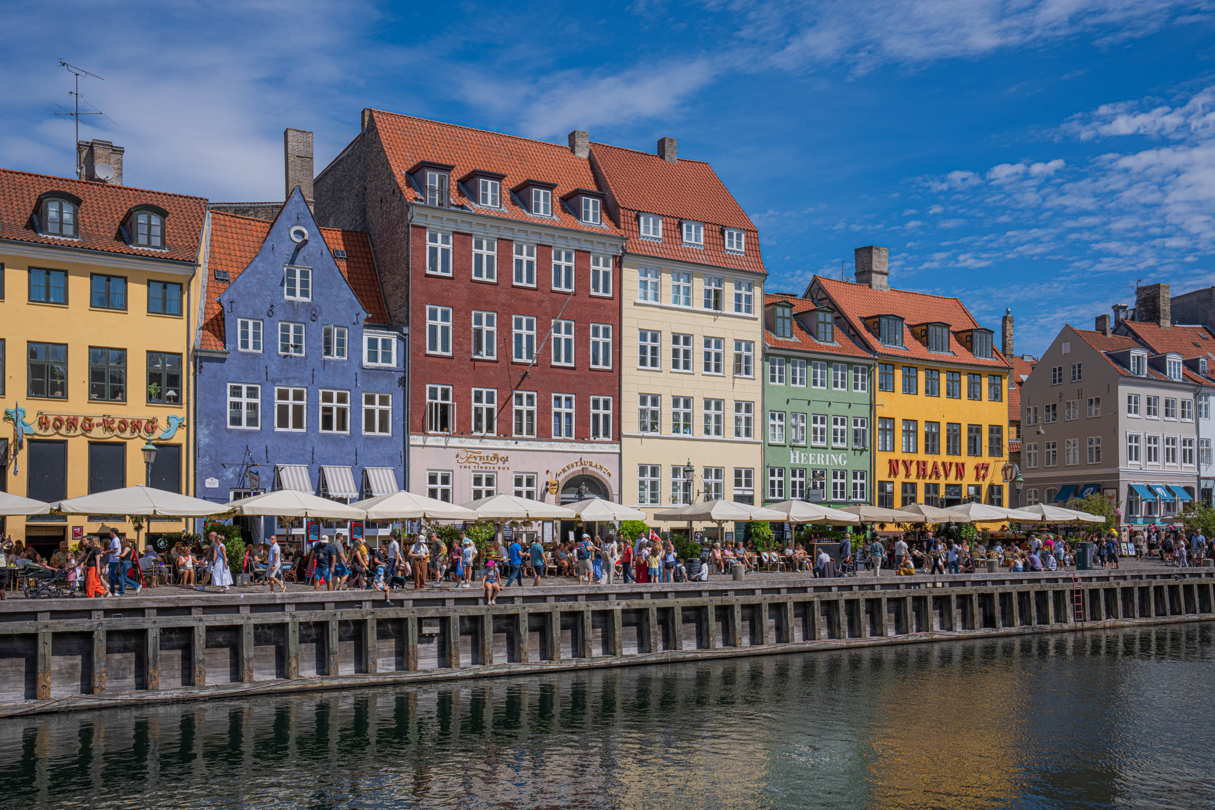 Classic Nyhavn view in Copenhagen with yellow, blue and red merchant houses reflected in the canal