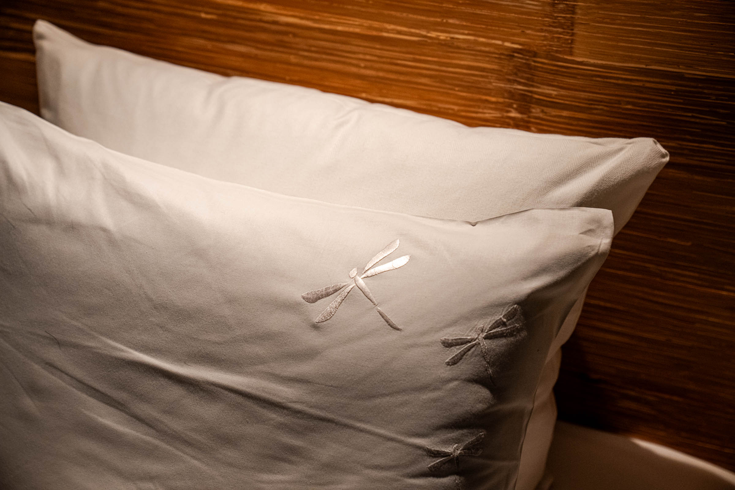 Close up of hotel bed linen at Manon Les Suites Guldsmeden with the embroidered dragonfly logo