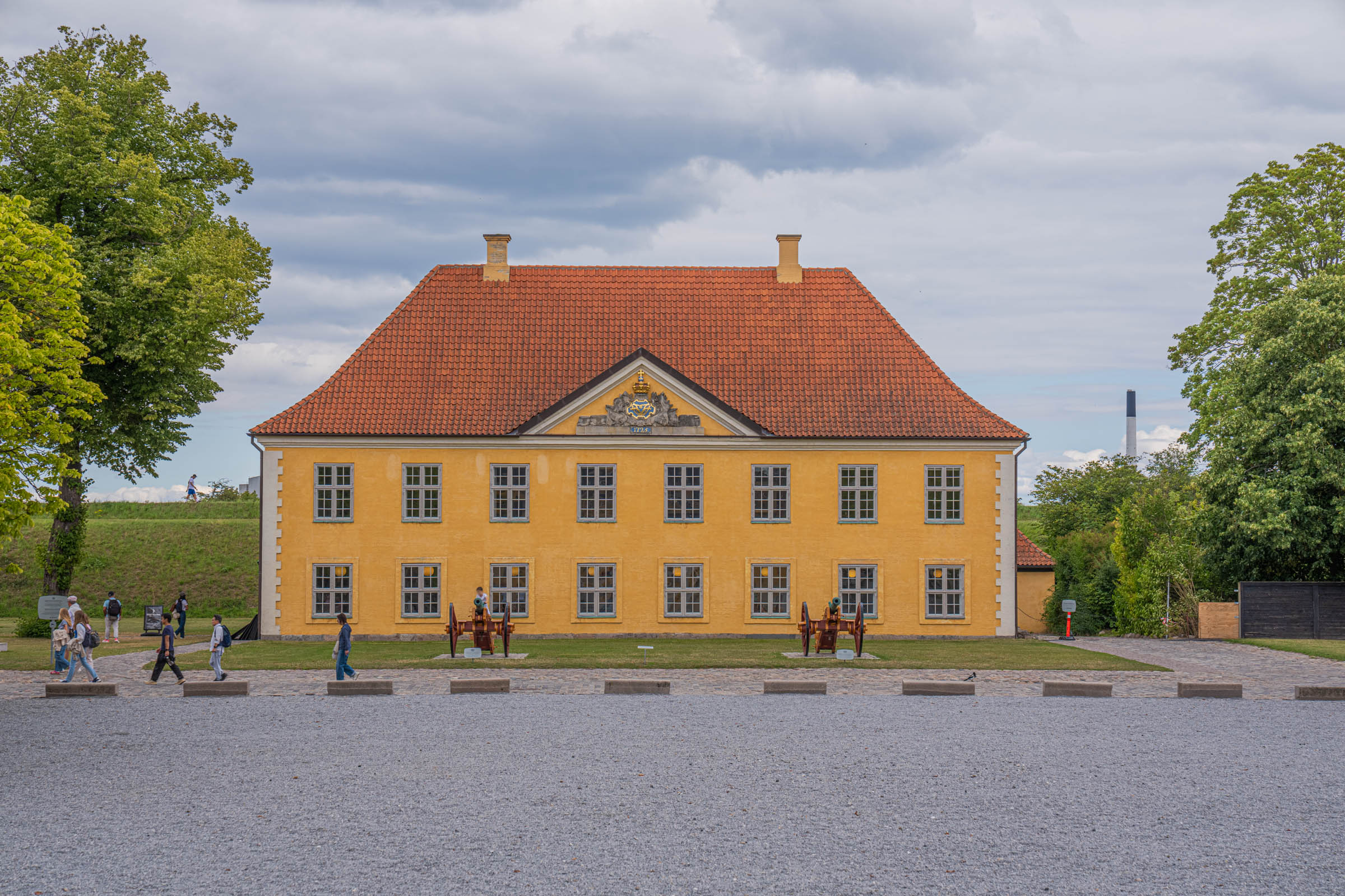 Yellow Commander's House at Kastellet in Copenhagen with two historic cannons on the gravel forecourt