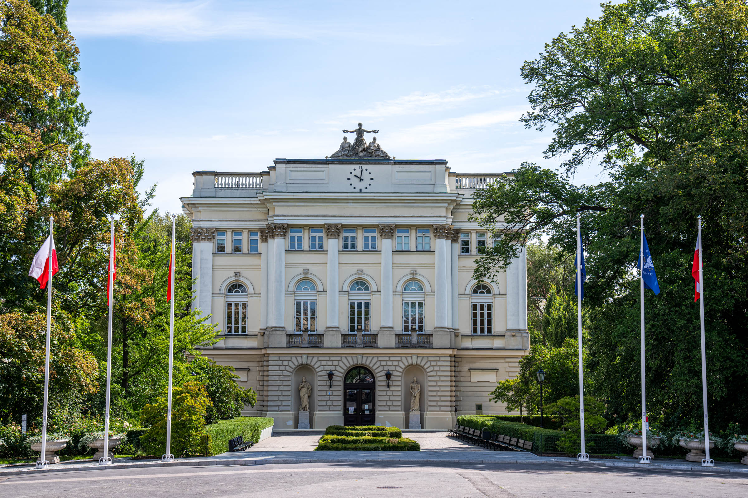 Kazimierzowski Palace, main building of the University of Warsaw, behind flags and hedges, Mr.M by Marko Tadić