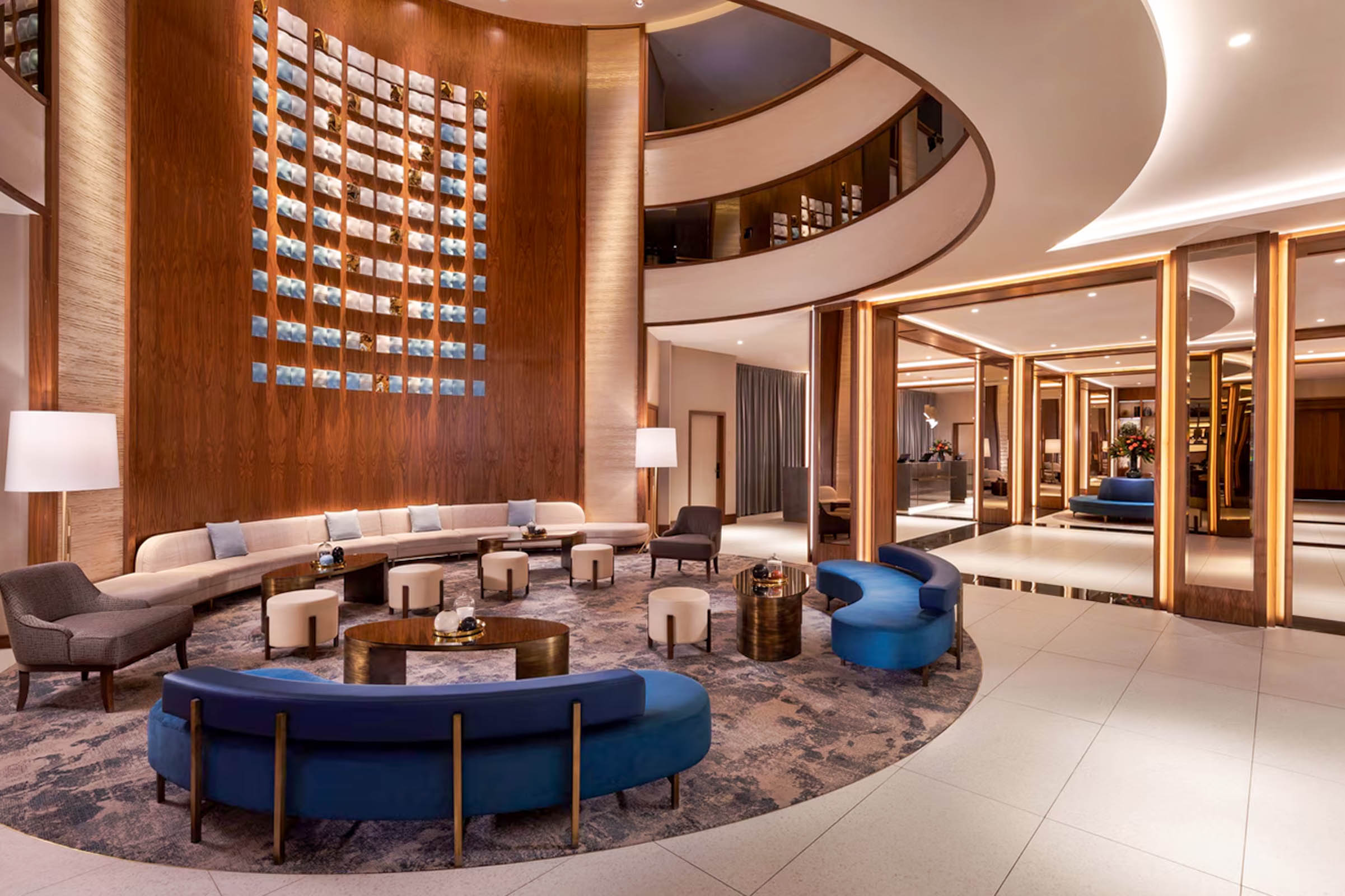 Renovated lobby of Sheraton Grand Warsaw with curved blue sofas and walnut panelling, Mr.M by Marko Tadić