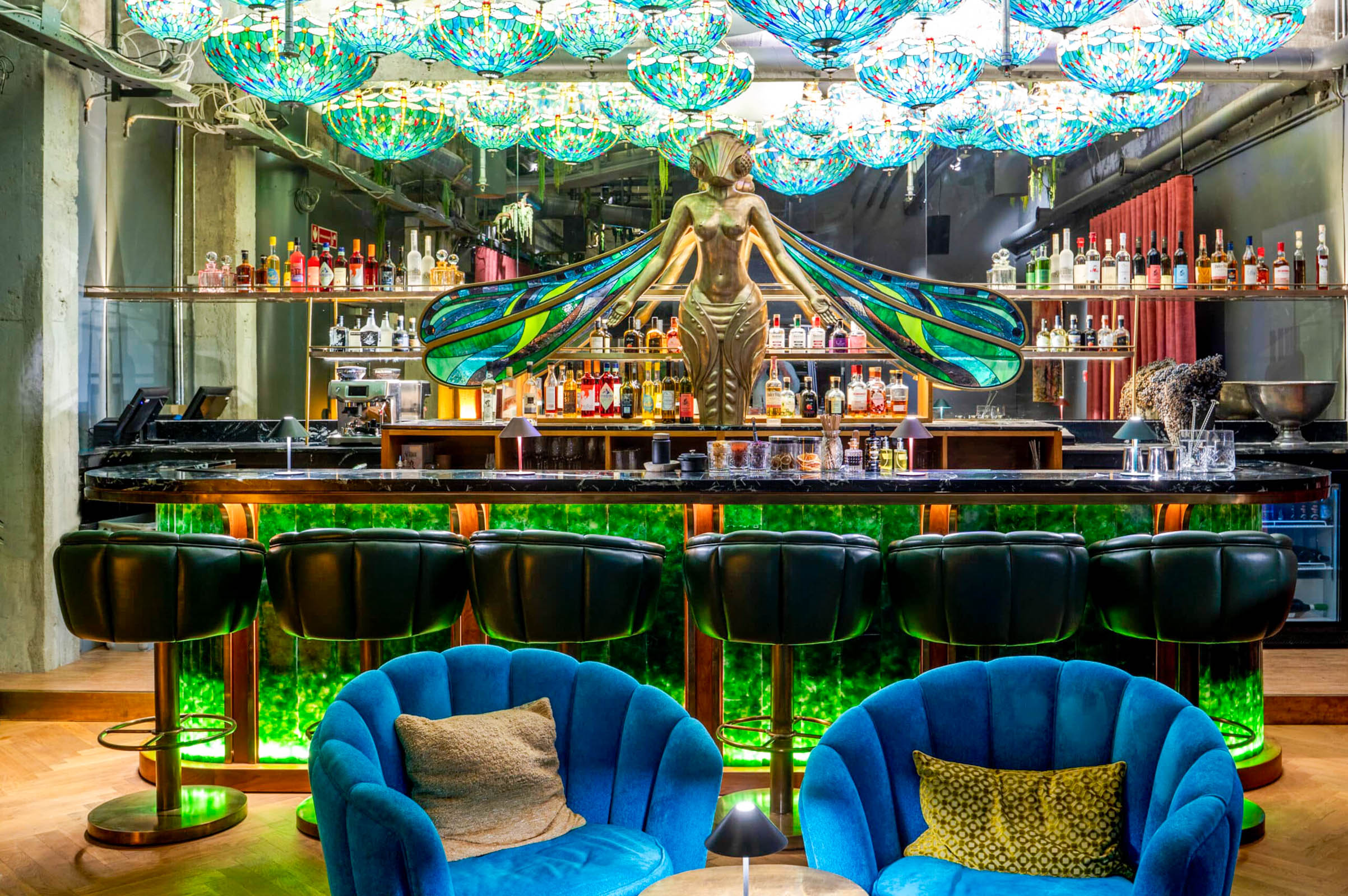 Bar Libelulle at Manon Les Suites with a gilded dragonfly figure, stained glass wings and Tiffany style lamps