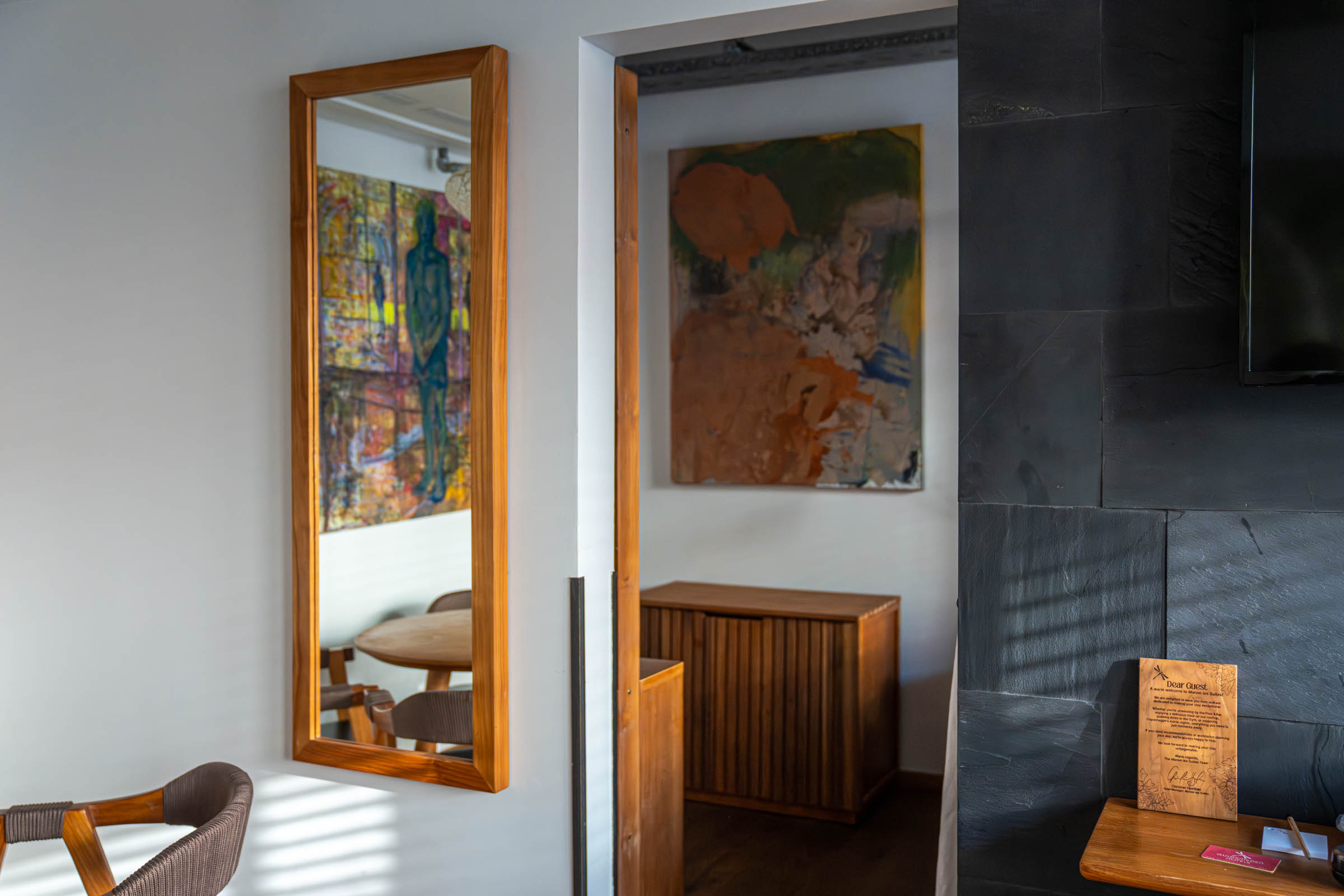 Full-length teak mirror reflecting a colourful canvas beside a slate wall in the Classic Suite, photo by Marko Tadić, founder of Mr.M blog