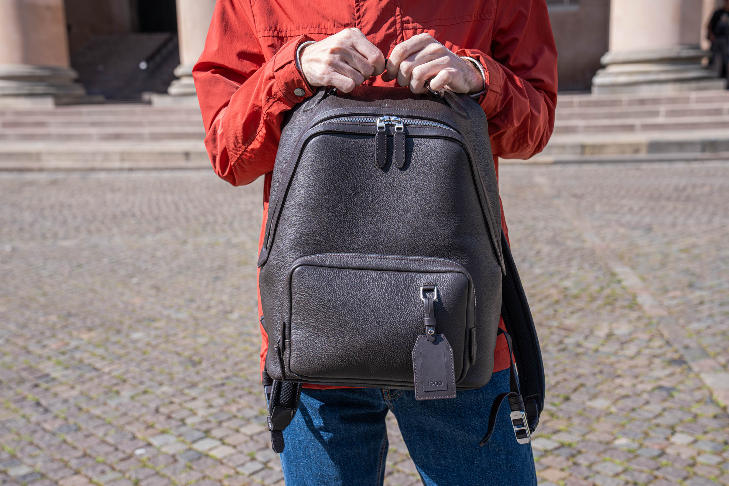 Fashion blogger Marko Tadić carrying the 1900 Tempo Grande leather backpack in front of the Ionic columns of the Copenhagen Court House designed by C.F. Hansen