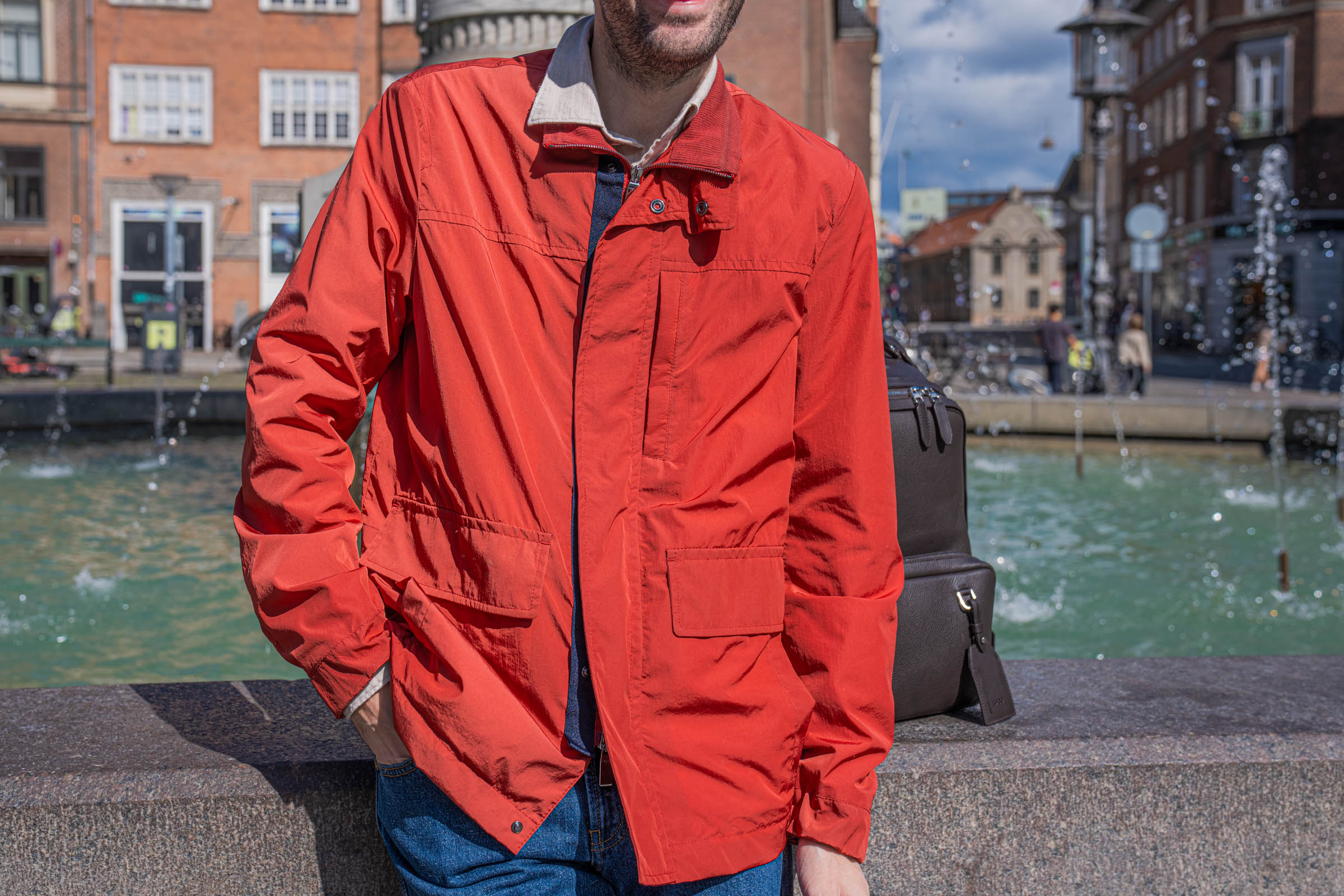 Front detail of the red Canali field jacket showing the corduroy stand collar, snap fastened placket, chest pocket and two flap pockets on technical fabric
