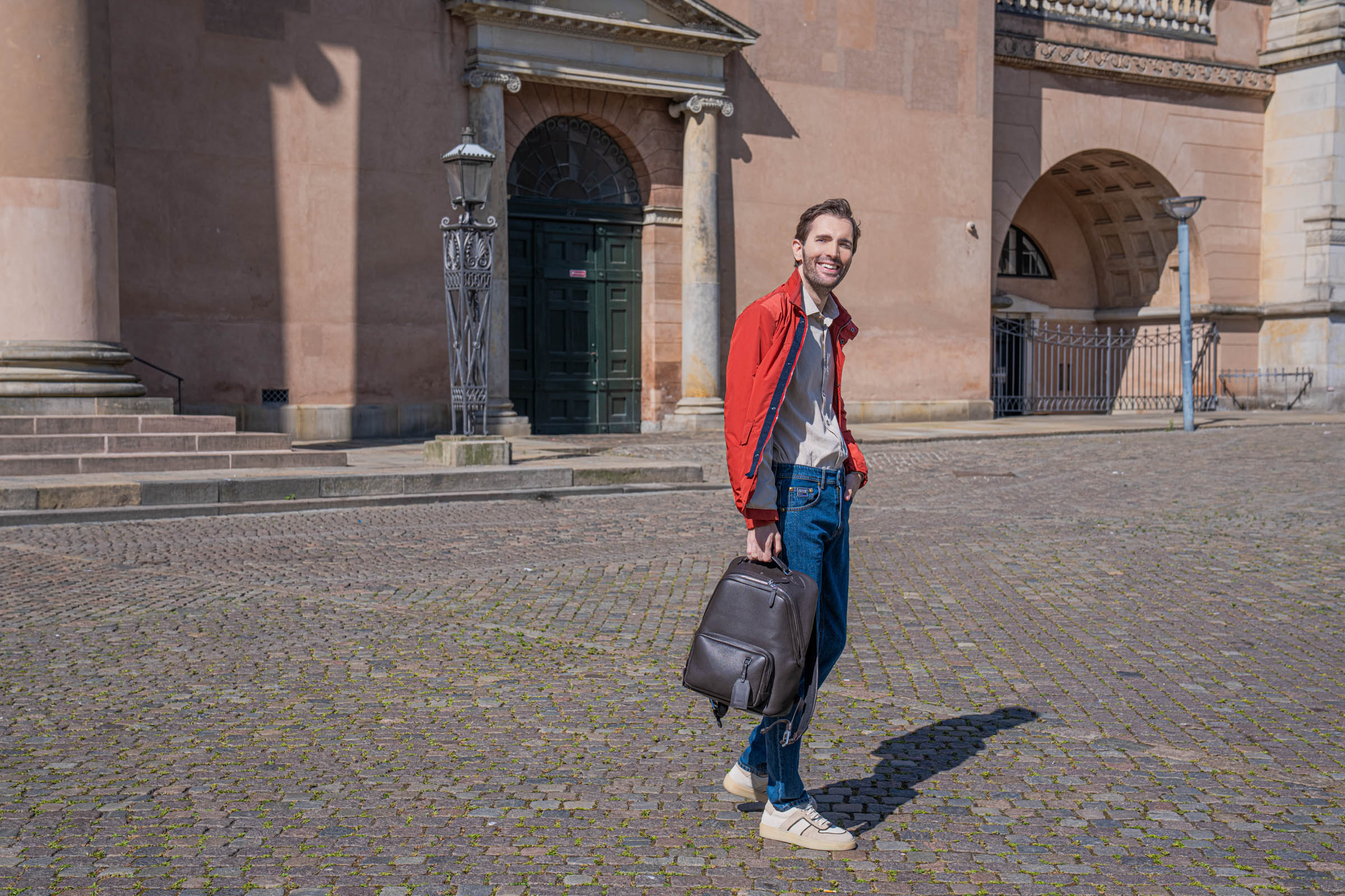Full length men's autumn outfit idea photographed at Gammeltorv, with Marko Tadić in a red Canali field jacket, Versace jeans and Carlos Santos Lonnie suede sneakers