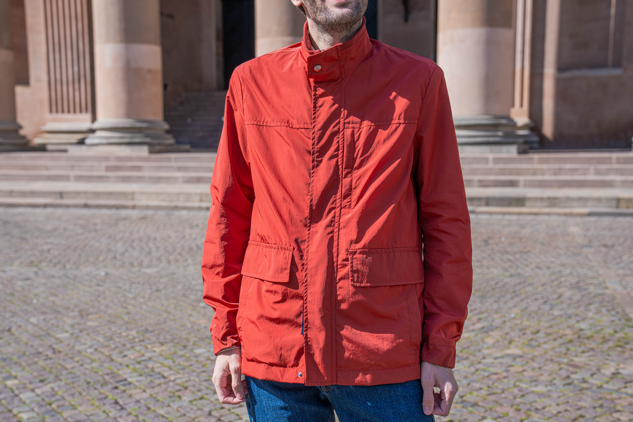 Detail of the corduroy lined stand collar, chest pocket and flap pockets on the red Canali field jacket, photographed beside the Caritas Fountain in Copenhagen