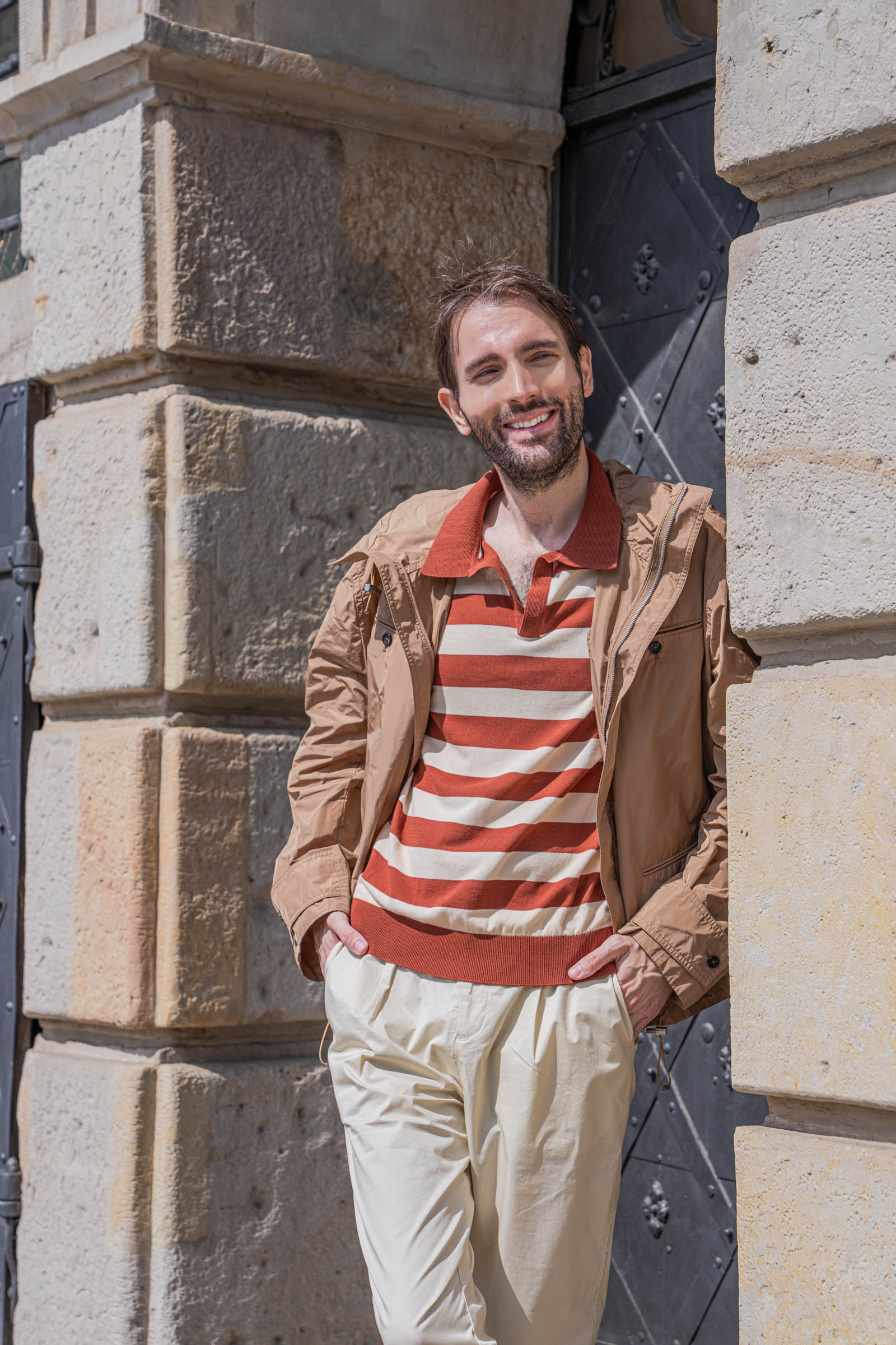 Marko Tadić posing beside the studded iron doors of an Old Town townhouse in Warsaw