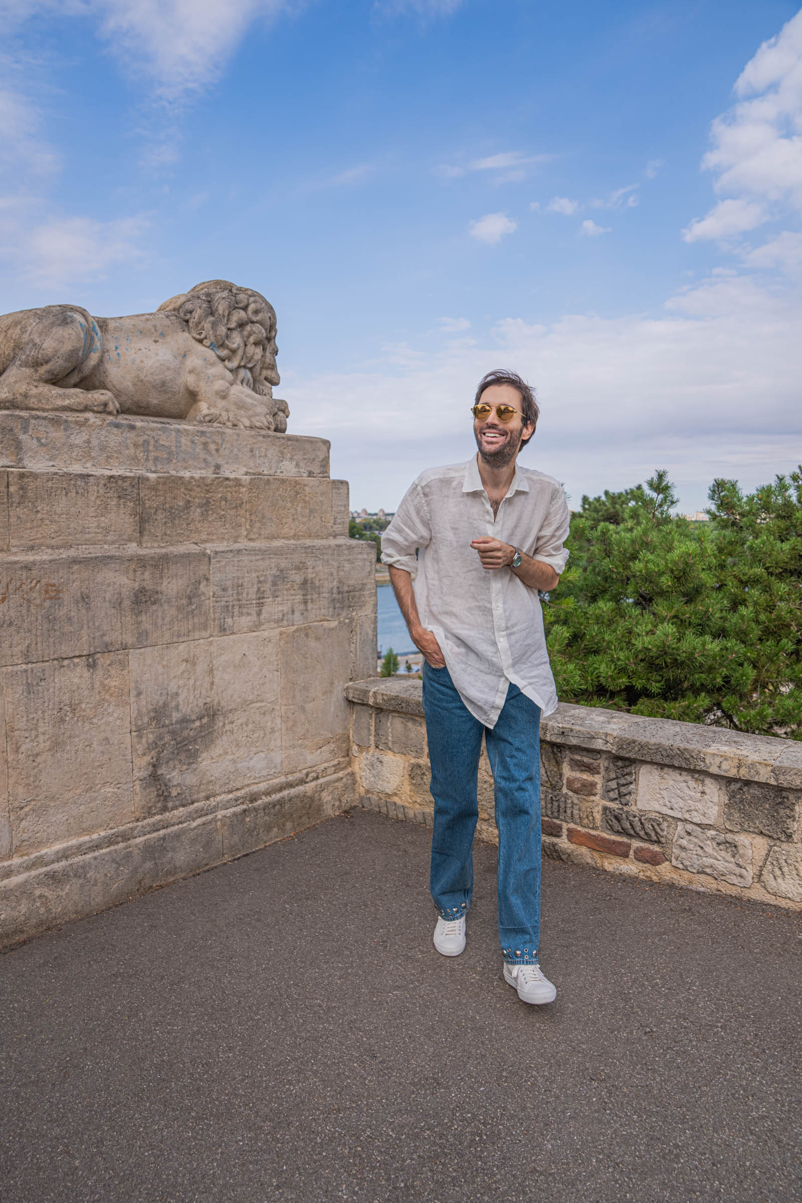 Marko Tadić, founder of Mr.M blog, in a Valentino summer outfit beside the stone lion at Belgrade Fortress
