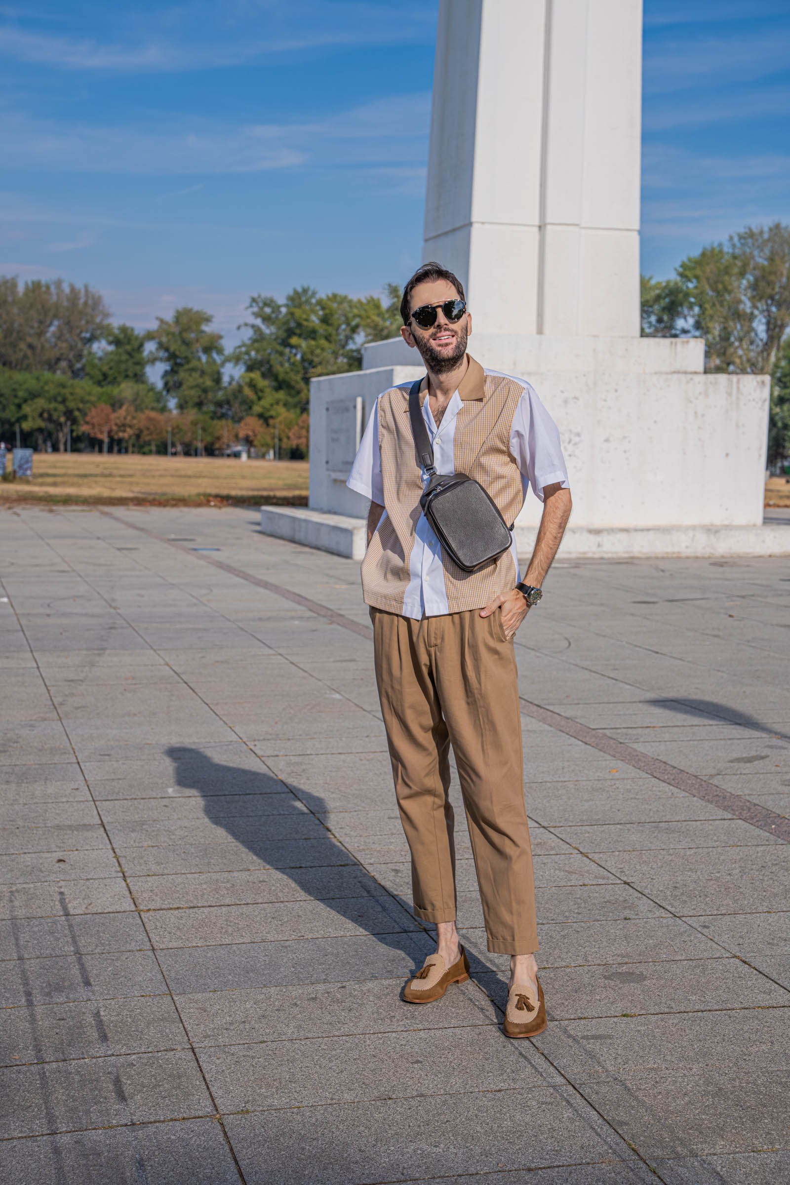 Full-length look of Marko Tadić, founder of Mr.M by Marko Tadić, in a Dsquared2 outfit with cropped tan trousers, crossbody bag and suede tassel loafers