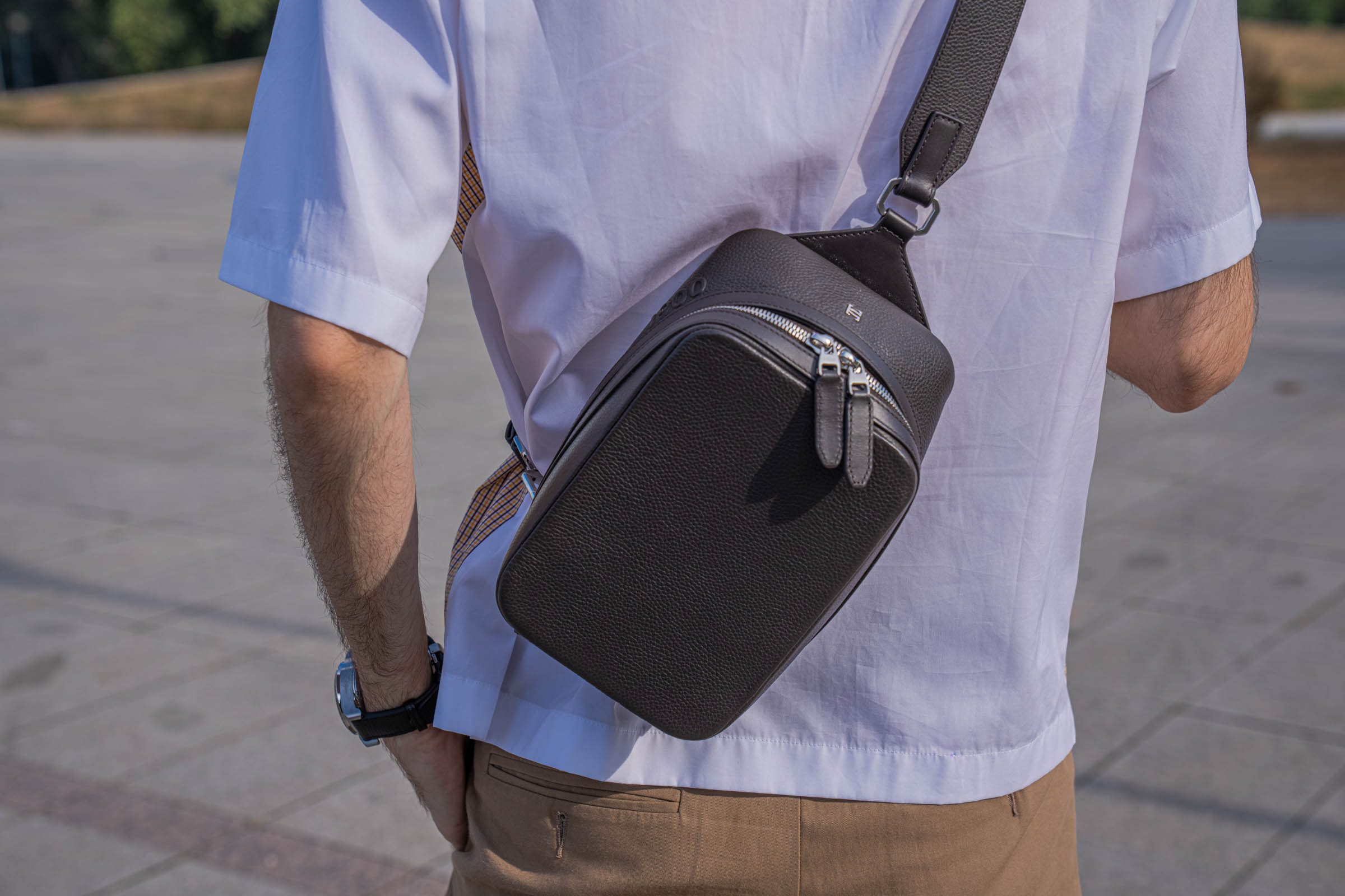Back view of Marko Tadić wearing the 1900 Tempo Grande Crossbody bag behind his shoulder over the white back of a Dsquared2 short-sleeve shirt
