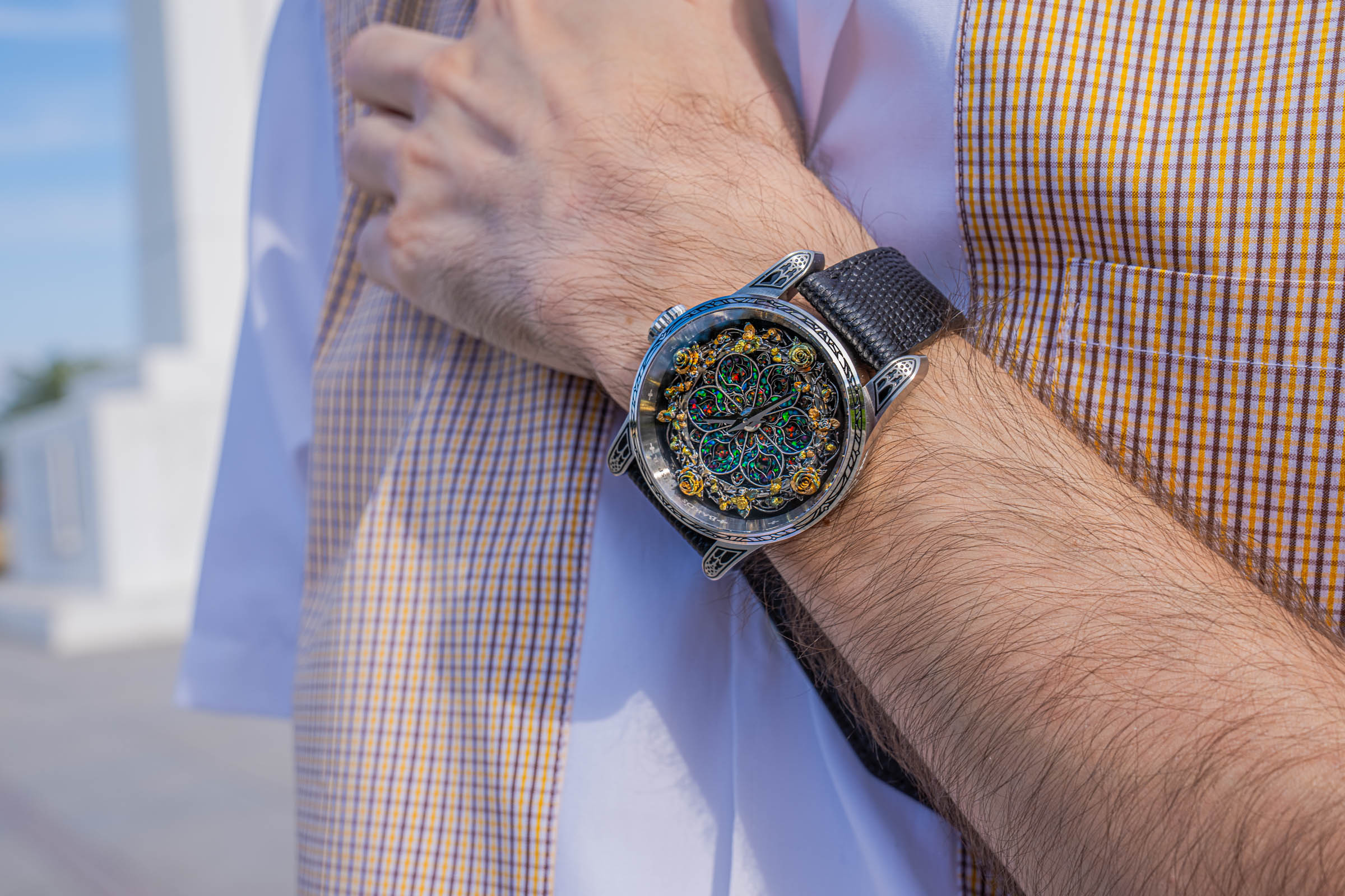 Close-up of the 45 mm Bard's Whisper Opal Crystal watch with gilded roses and Gothic lugs, worn by Marko Tadić with a Dsquared2 outfit in mustard and white