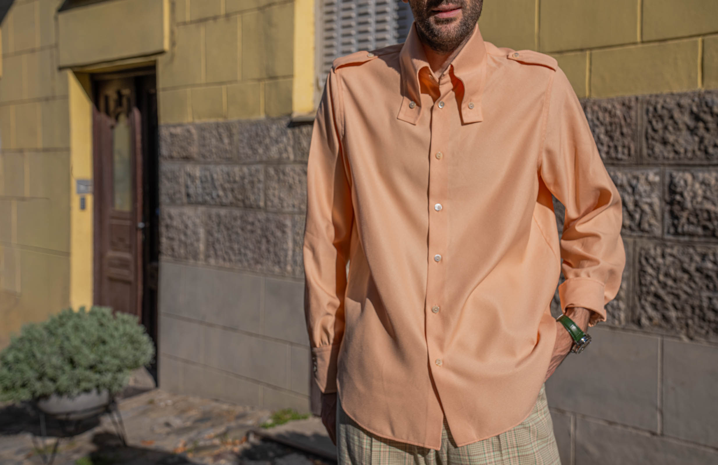 Long button-down collar, epaulettes and pearly buttons on Marko Tadić's peach Gucci silk shirt