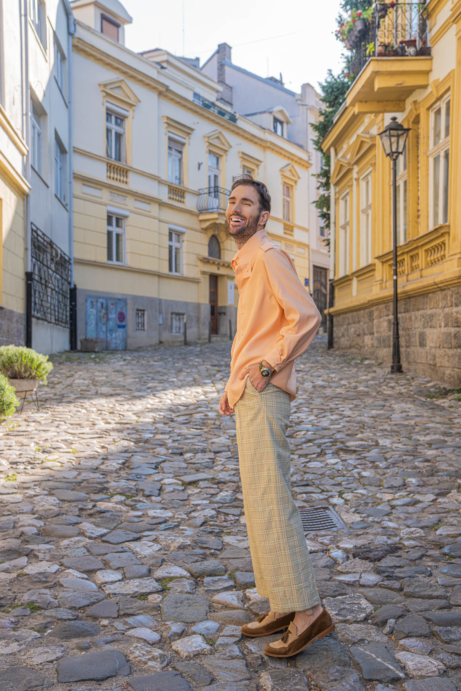 Marko Tadić laughs in profile, showing the fluid drape of a Gucci silk shirt and straight-cut check trousers