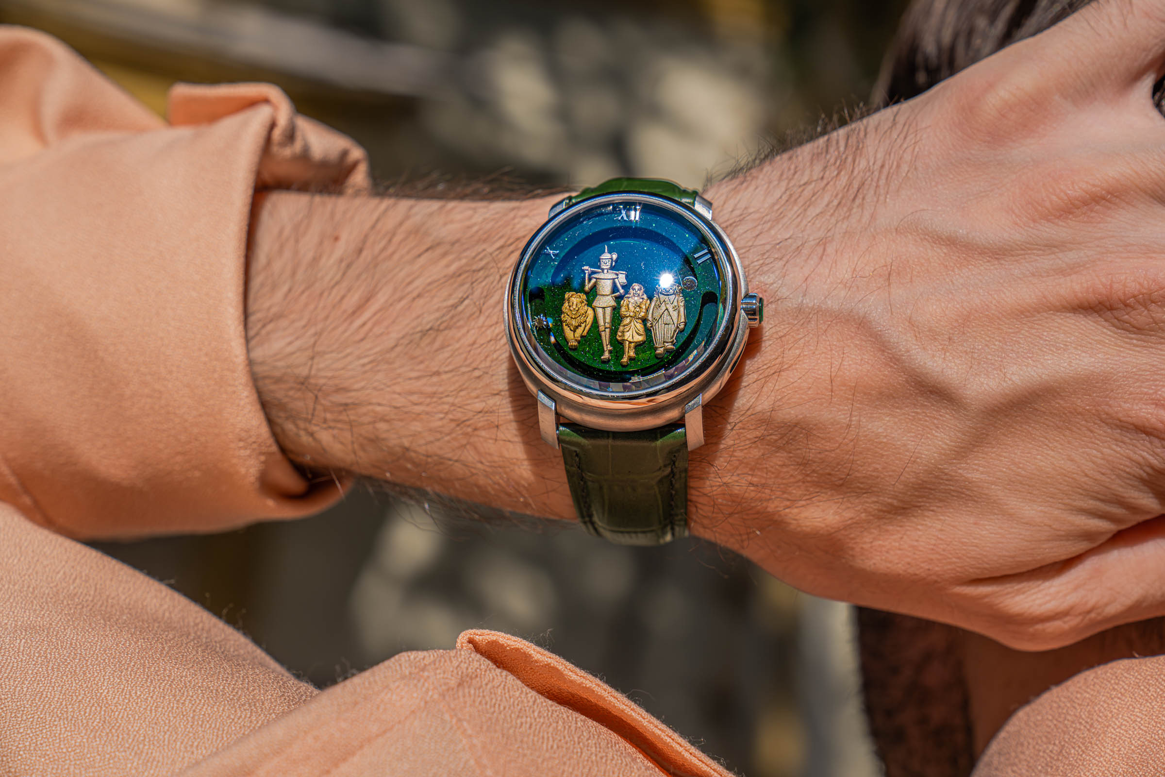 Marko Tadić's wrist with the Dmitry Chugunov watch: blue and green aventurine sky with gold and silver figures