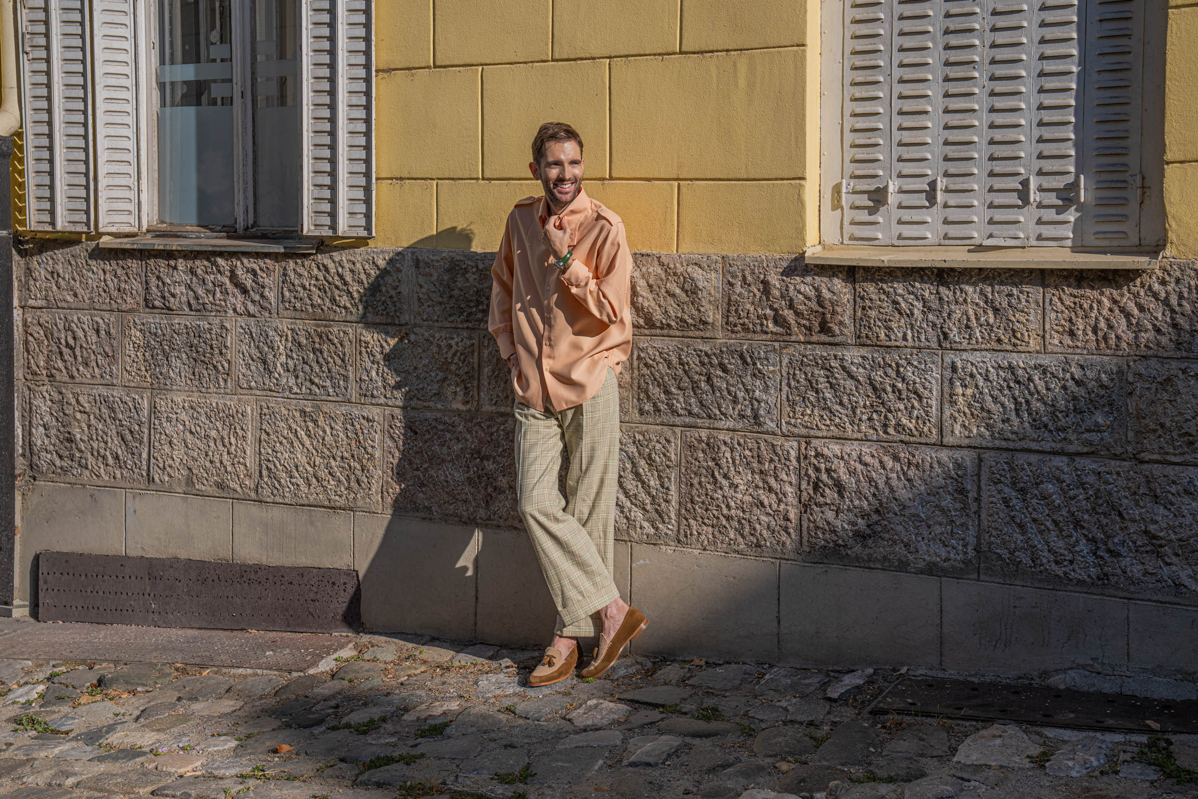 Smiling Marko Tadić against a wall with white shutters, an effortless Italian look by Gucci and Fratelli Rossetti