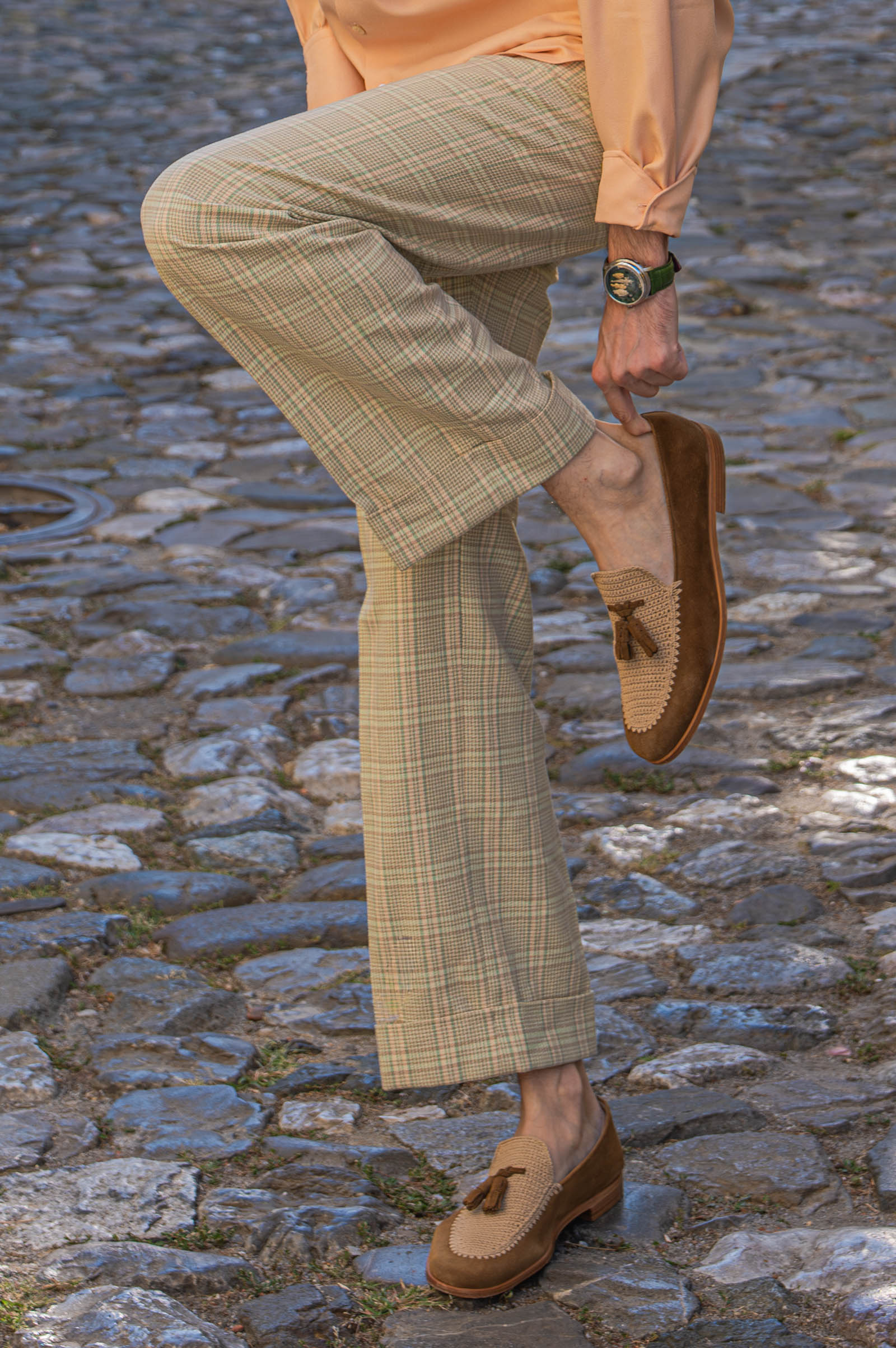 Marko Tadić adjusts a Fratelli Rossetti Brera crochet loafer, the green Chugunov watch on his wrist