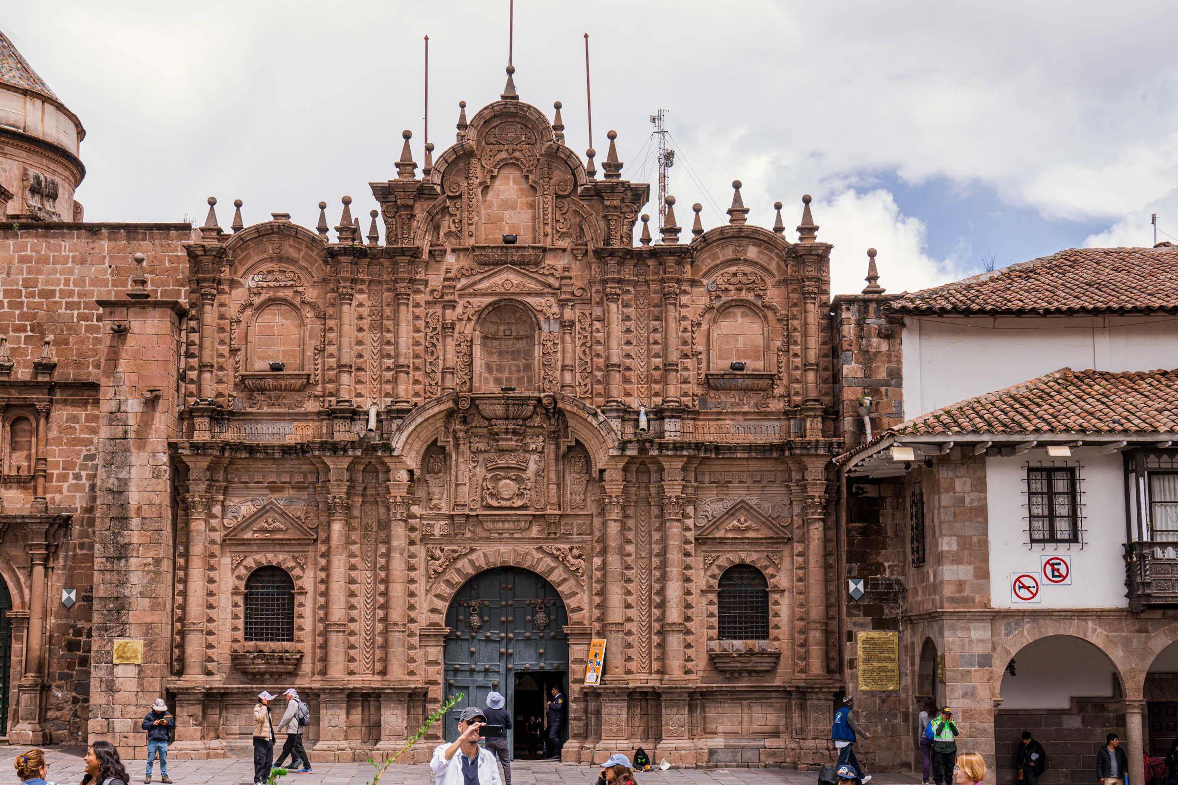 Kameni ulaz samostana Santa Catalina u Kusku sa ukrašenom kapijom i kupolom crkve na vrhu, autentična urbana scena Perua.