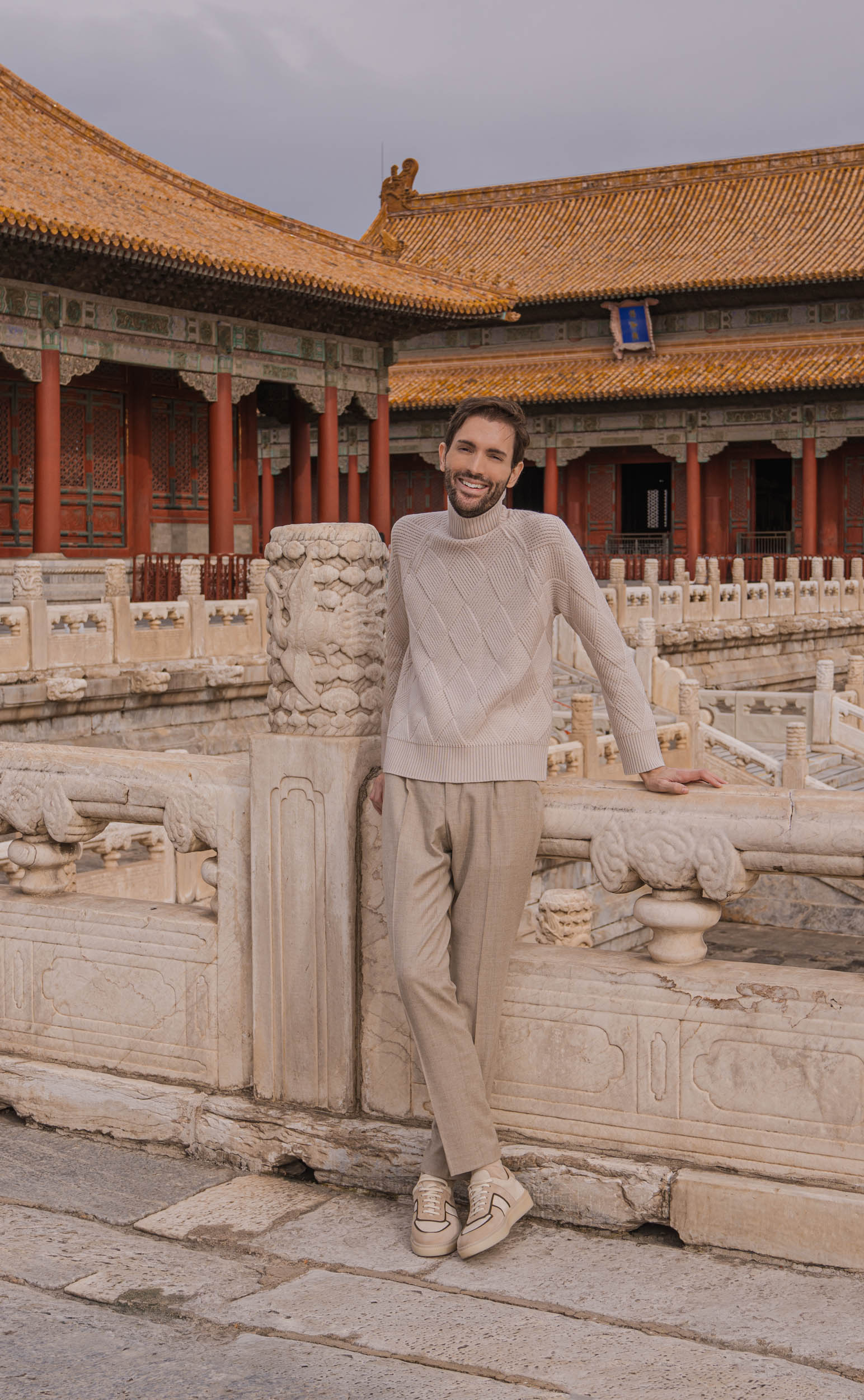 Marko Tadić u potpunoj bež kombinaciji hoda kroz dvorište Hale Vojne Eminencije u Zabranjenom Gradu sa carskim žutim krovnim crepovima u pozadini