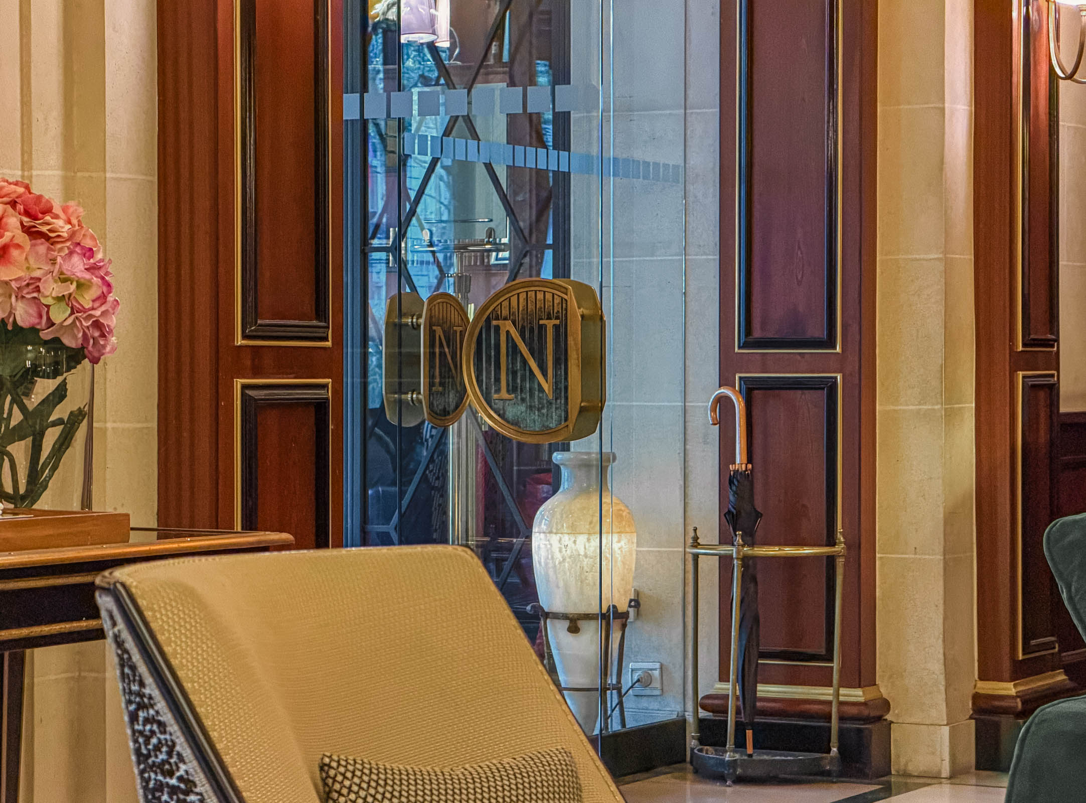 Staklena ulazna vrata sa pozlaćenim monogramom „N” hotela Hôtel Napoléon